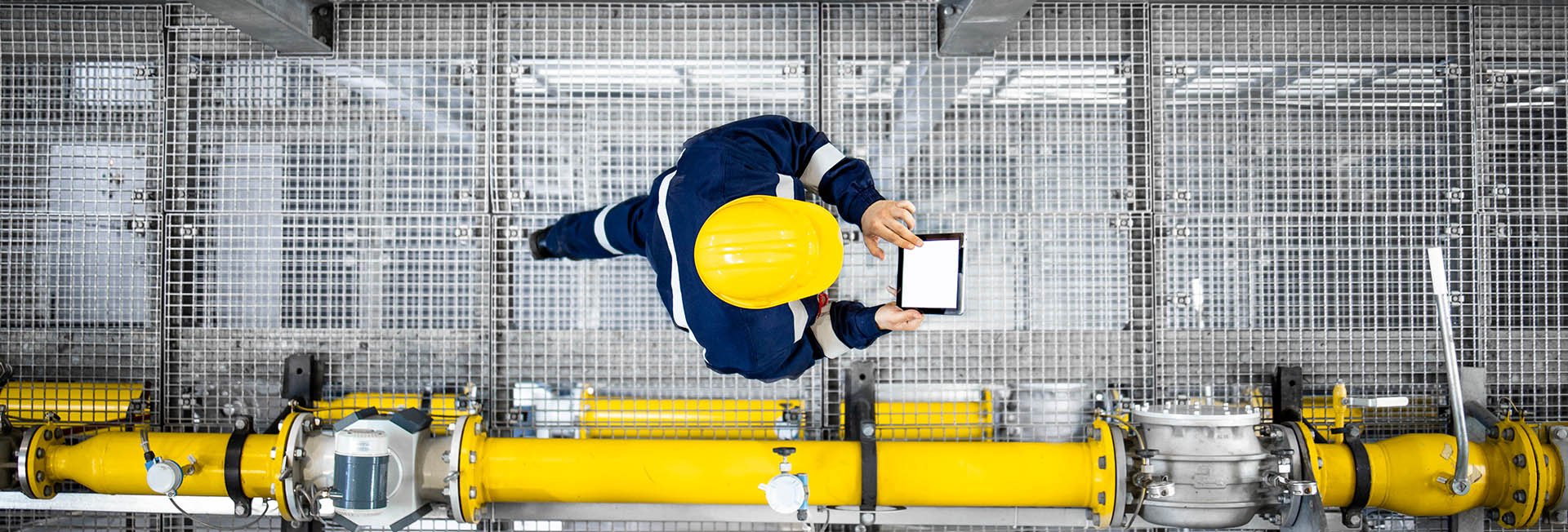 Reduce your emissions with DSO/Upstream: image of worker with tablet checking operations in the plant